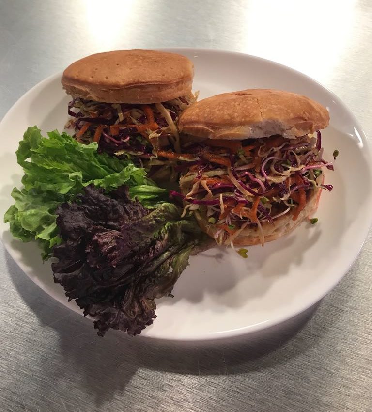 Hamburguesa de pescado y ensalada fresca.