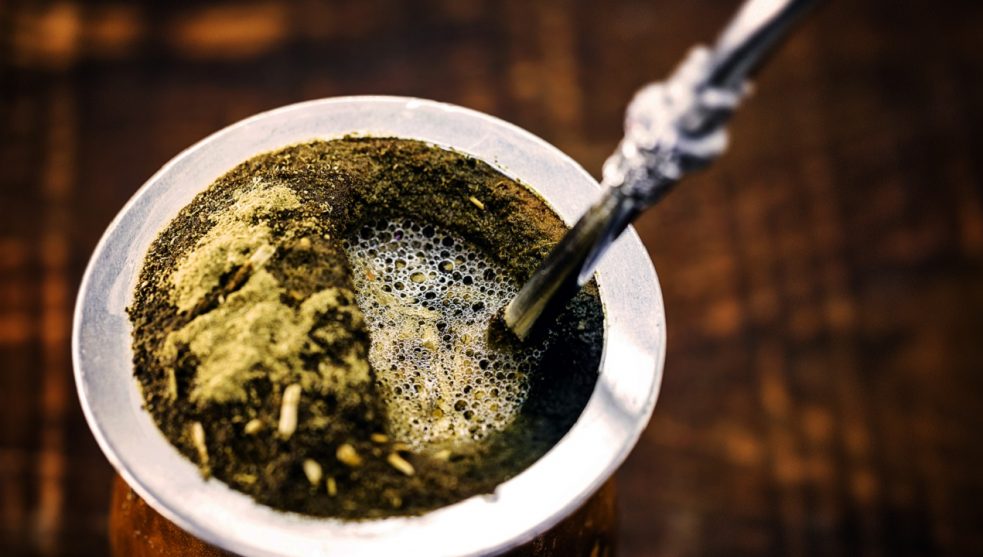 Yerba mate tea in calabash on wooden table. Traditional Argentine, Uruguayan and Brazilian drink